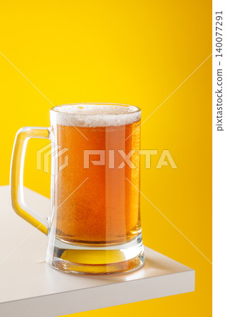 Beer mug with foam yellow background snack setup Beer mug with foam yellow background snack setup 140077291