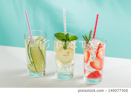 Set of fresh non alcoholic drinks with strawberry cucumber and lemon on blue background Set of fresh non alcoholic drinks with strawberry cucumber and lemon on blue background 140077308