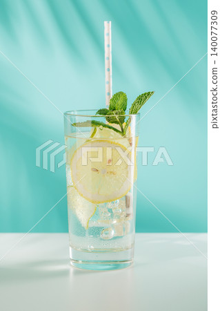 Fresh lemon and mint non alcoholic drink with ice on blue background Fresh lemon and mint non alcoholic drink with ice on blue background 140077309