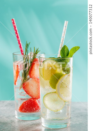 Two fresh non alcoholic drinks with strawberry and lemon on blue background Two fresh non alcoholic drinks with strawberry and lemon on blue background 140077312