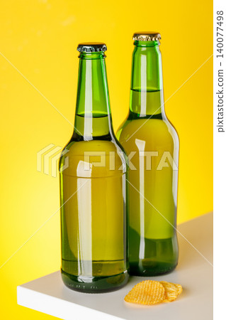 Green glass beer bottles on yellow background minimal studio composition Green glass beer bottles on yellow background minimal studio composition 140077498