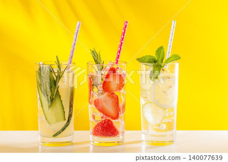 Set of fresh non alcoholic drinks with strawberry cucumber and lemon on yellow background 140077639