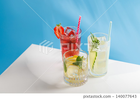 Assortment of non alcoholic refreshing drinks with herbs and citrus on blue background Assortment of non alcoholic refreshing drinks with herbs and citrus on blue background 140077643