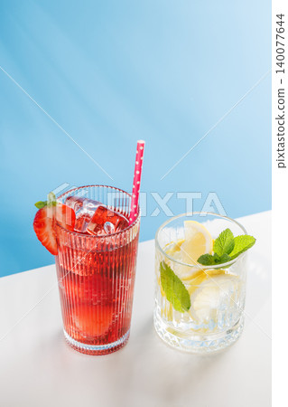 Fresh strawberry and lemon non alcoholic drinks with mint on blue background Fresh strawberry and lemon non alcoholic drinks with mint on blue background 140077644