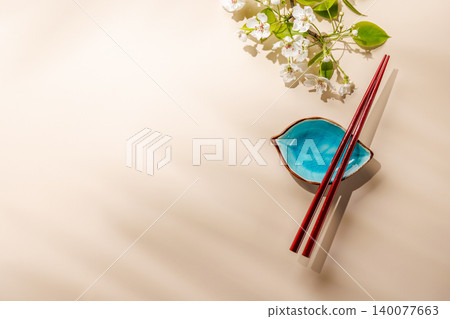 Minimal asian composition with chopsticks and blossom branch 140077663