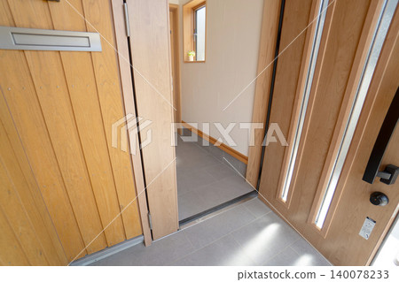 A clean and bright entrance hall in a newly built Japanese detached house with wooden walls and tiled flooring. A clean and bright entrance hall in a newly built Japanese detached house with wooden walls and tiled flooring. 140078233