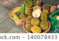 Fresh durian fruits with spiky shell for sale in bamboo baskets on street market 140078433