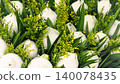 Beautiful white lotus flower buds decorated with yellow flowers and green leaves for religious offering 140078435