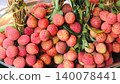 Fresh ripe lychee fruits in bunches with green leaves on a tray 140078441