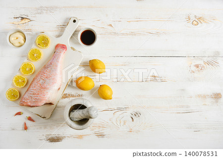 Preparing red snapper with lemon and spices on wooden table for cooking Preparing red snapper with lemon and spices on wooden table for cooking 140078531