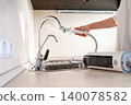 Cleaning the kitchen surface with a steam cleaner next to the sink at home 140078582