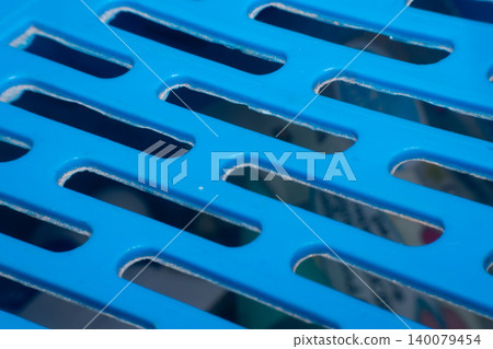 Closeup of blue plastic grid surface showing geometric openings smooth texture industrial design modern material detail for abstract backgrounds Closeup of blue plastic grid surface showing geometric openings smooth texture industrial design modern material detail for abstract backgrounds 140079454