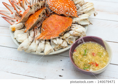 Fresh steamed blue crab served plate spicy seafood dipping sauce Traditional seafood cuisine closeup white wooden table copy space Fresh steamed blue crab served plate spicy seafood dipping sauce Traditional seafood cuisine closeup white wooden table copy space 140079471