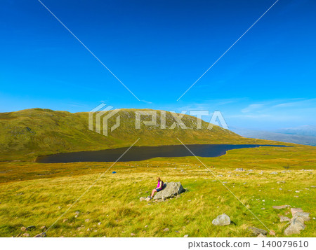 Hikers rest overlooking the lake on the Ben Nevis trail (United Kingdom, Scotland) Hikers rest overlooking the lake on the Ben Nevis trail (United Kingdom, Scotland) 140079610