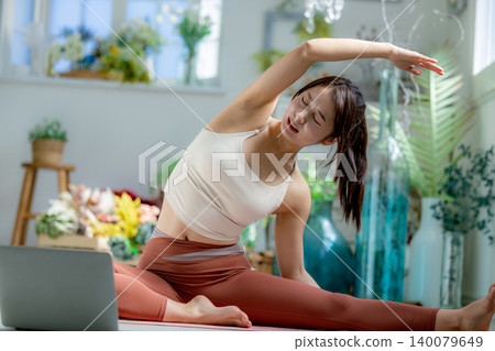 一個年輕的女人，做瑜伽在線 140079649