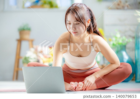 一個年輕的女人，做瑜伽在線 140079653