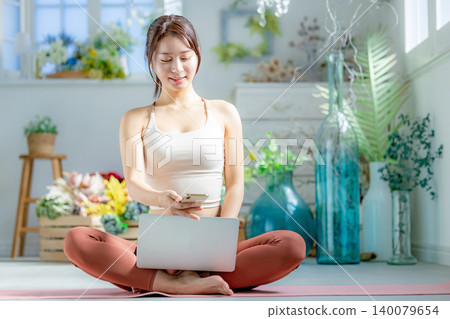 一個年輕的女人，做瑜伽在線 140079654