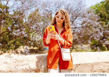 Young woman using smart phone and smile with walking in city outdoor. Business, blogging concept. 140079964