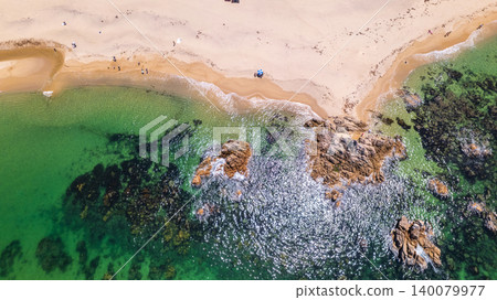 [Top View] Drone aerial footage of the area around Suishohama Beach, showcasing the contrast between the emerald green sea and white sand. 140079977