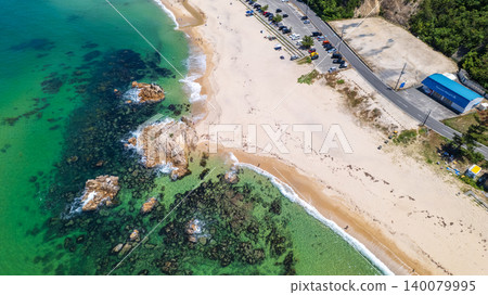 [Top View] Drone footage of the crystal-clear waters and rocky reefs at Diamond Long Beach in Mihama Town. 140079995