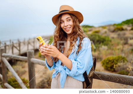 Woman tourist with phone enjoying beautiful views. Europe travel. Lifestyle, nature, active life. Woman tourist with phone enjoying beautiful views. Europe travel. Lifestyle, nature, active life. 140080093