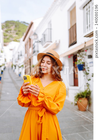 Female traveler in a beautiful yellow dress is sightseeing in European cities. Travel, tourism Female traveler in a beautiful yellow dress is sightseeing in European cities. Travel, tourism 140080196