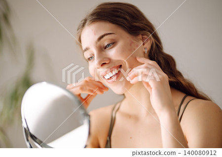 Young woman with problem skin looking into mirror. Inflammation on face, problem skin. Beauty care. Young woman with problem skin looking into mirror. Inflammation on face, problem skin. Beauty care. 140080912
