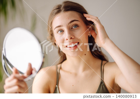 Young woman with problem skin looking into mirror. Inflammation on face, problem skin. Beauty care. Young woman with problem skin looking into mirror. Inflammation on face, problem skin. Beauty care. 140080913
