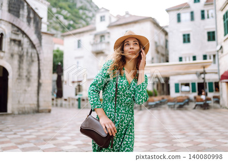 Young beautiful woman in trendy summer dress posing in street. Fashion style. Tourist attraction. 140080998
