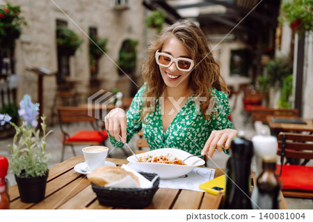 Woman eating italian pasta and drinking coffee at restaurant on the street in Rome. Food and drink. Woman eating italian pasta and drinking coffee at restaurant on the street in Rome. Food and drink. 140081004