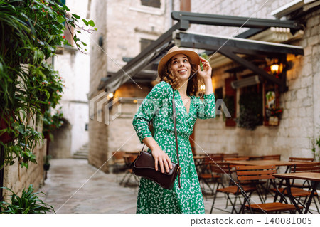 Young beautiful woman in trendy summer dress posing in street. Fashion style. Tourist attraction. 140081005
