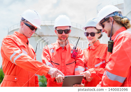 Engineers reviewing data on tablet at oil facility site Engineers reviewing data on tablet at oil facility site 140081096