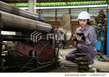 Female industrial worker in hardhat at manufacturing plant. 140081207