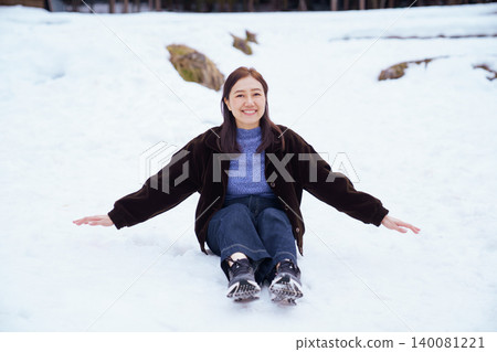 Smiling female tourist enjoying winter vacation on snow 140081221