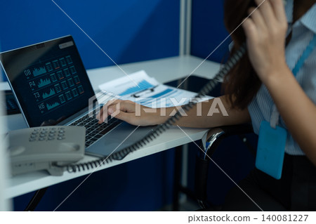 Consulent speaking to mobile cellphone at home office. women speak with remote clients using phone. Laptop on the desk. Consulent speaking to mobile cellphone at home office. women speak with remote clients using phone. Laptop on the desk. 140081227