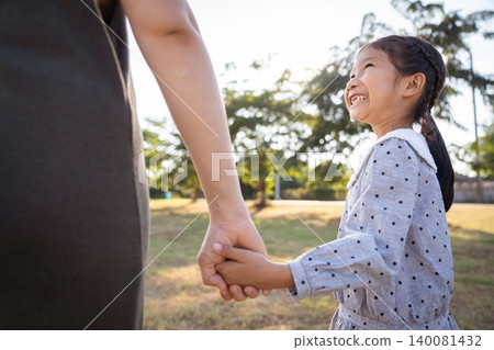 Happy Asian mother and daughter smiling together in the park Happy Asian mother and daughter smiling together in the park 140081432