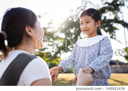 Happy Asian mother and daughter smiling together in the park Happy Asian mother and daughter smiling together in the park 140081436