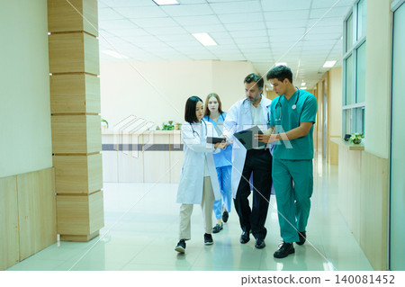 Group of diverse doctors walking and discussing in hospital corridor Group of diverse doctors walking and discussing in hospital corridor 140081452