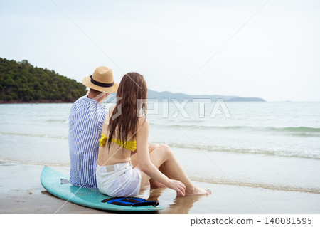 Young Couple Sitting on Surfboard Watching the Ocean at Beach 140081595