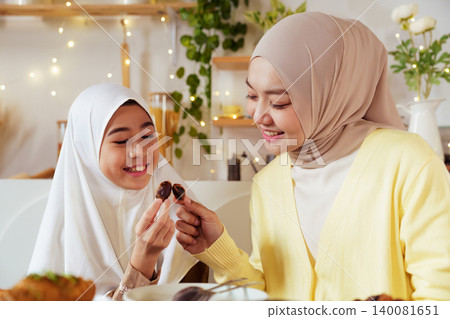 Muslim Mother and Daughter Breaking Fast with Dates in Ramadan Muslim Mother and Daughter Breaking Fast with Dates in Ramadan 140081651