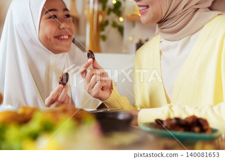 Muslim Mother and Daughter Breaking Fast with Dates in Ramadan Muslim Mother and Daughter Breaking Fast with Dates in Ramadan 140081653