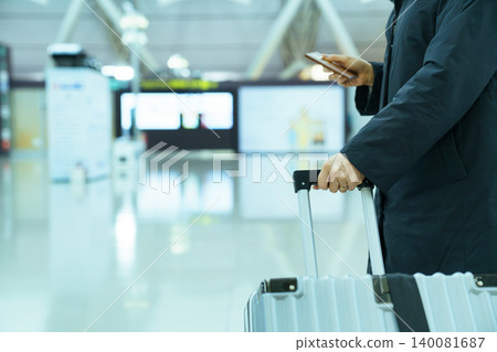 Passenger with Luggage and Passport in Airport Terminal 140081687