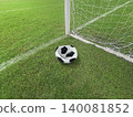 Deflated soccer ball on green grass field near the goal post, failure or missed opportunity concept 140081852