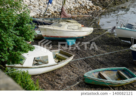 Old boats on the shore line in various state of decay Old boats on the shore line in various state of decay 140082121