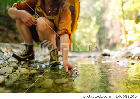 Traveler walks along forest hiking trail in mountains against the backdrop of mountain nature. Traveler walks along forest hiking trail in mountains against the backdrop of mountain nature. 140082209