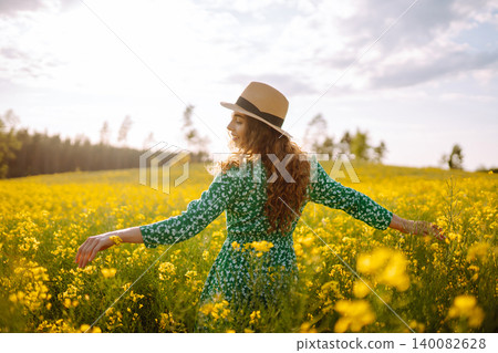 Young woman walking flowering field gently touch yellow flowers. Summer landscape. Young woman walking flowering field gently touch yellow flowers. Summer landscape. 140082628