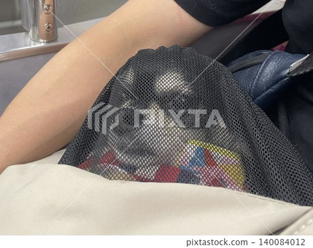 一隻博美犬和吉娃娃的混種幼犬在運送過程中被放入網中。 140084012