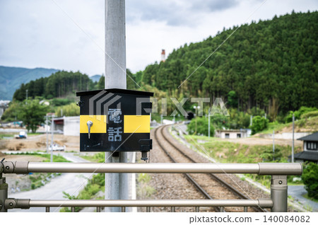 A railway telephone storage box and tracks installed on the platform of a local station. 140084082