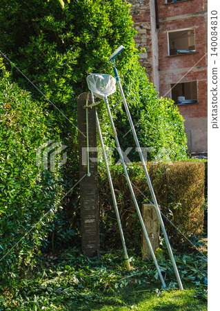 Pool maintenance equipment and cleaning tools beside swimming pool in Mediterranean countryside garden 140084810