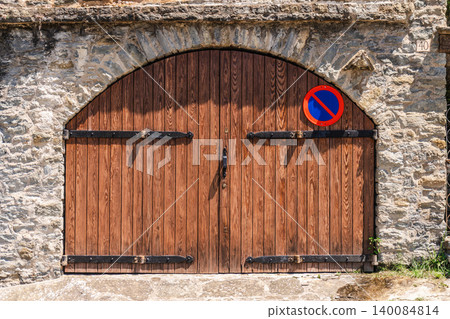 Old wooden arched door set in traditional stone wall in Rupit village, Catalonia, Spain, showcasing rustic craftsmanship Old wooden arched door set in traditional stone wall in Rupit village, Catalonia, Spain, showcasing rustic craftsmanship 140084814